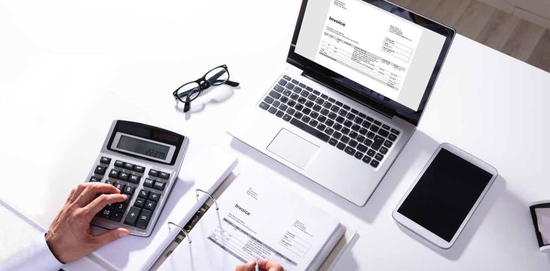 hesap makinesiyle hesap yaparak bilgisayar ekranına yazan bir el