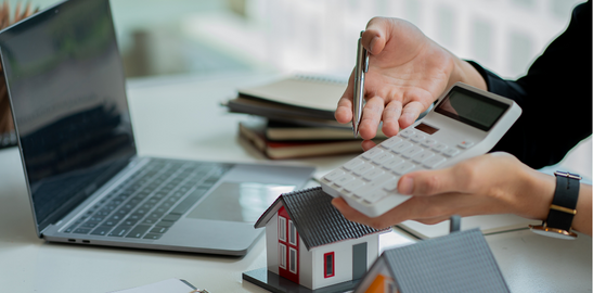 ev maketleri ve bilgisayar önünde anlaşma yapan iki insan