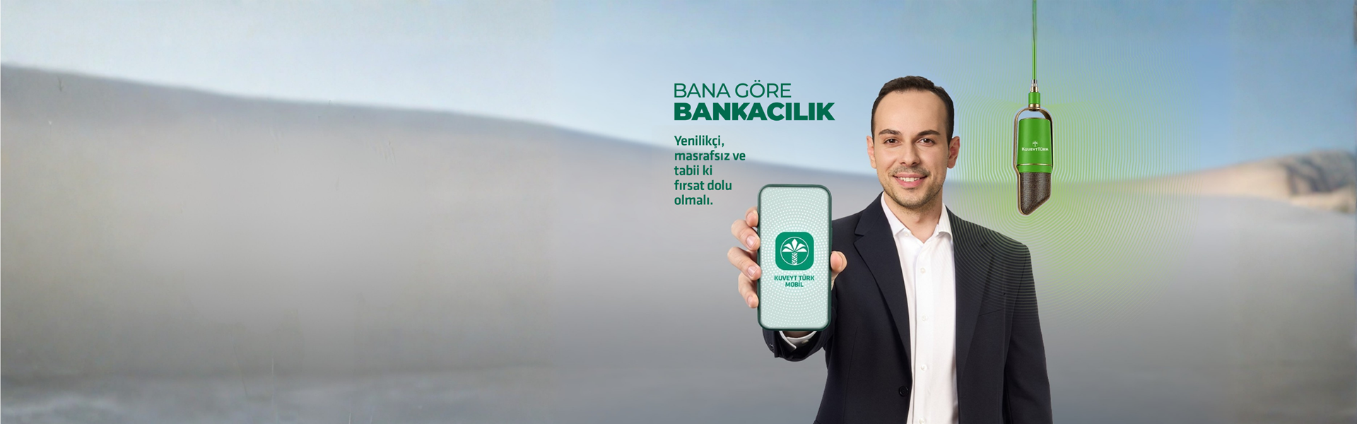 genç adam elinde telefon gösteriyor ve ekranda Kuveyt Türk Mobil yazısı var