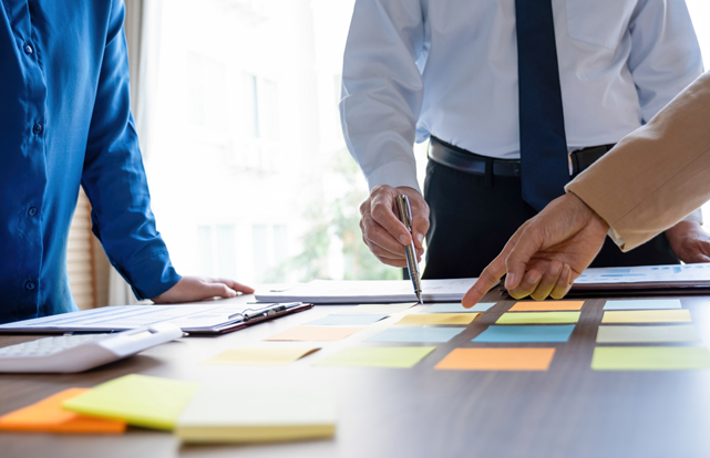 bir masa etrafında startup geliştiren üç profesyonel