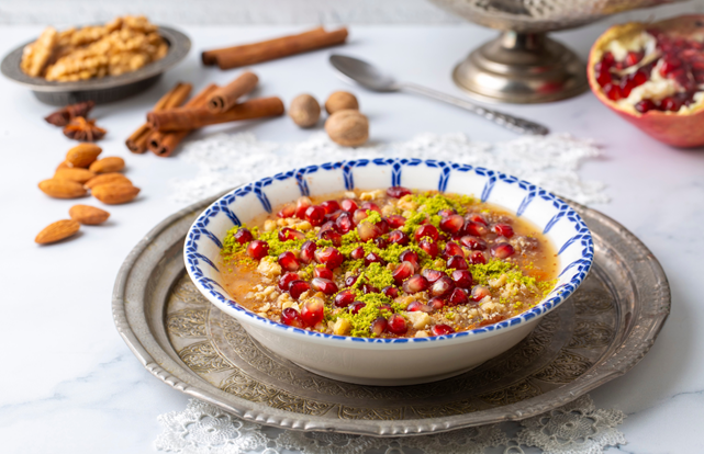yemek masası üzerinde üzeri süslenmiş aşure tabağı