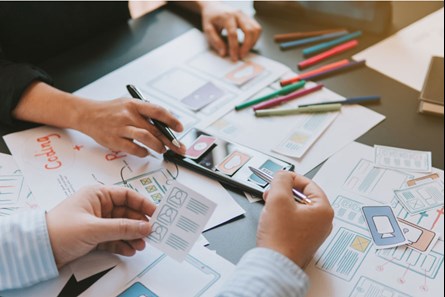 masa üzerinde infografik raporu hazırlayan iki kişi
