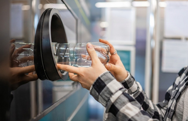plastik şişe otomatına plastik şişe atan kişi