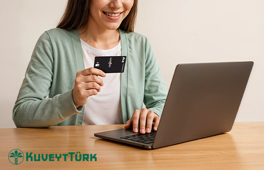 bilgisayardan işlem yaparken diğer elinde sağlam kart tutan kadın