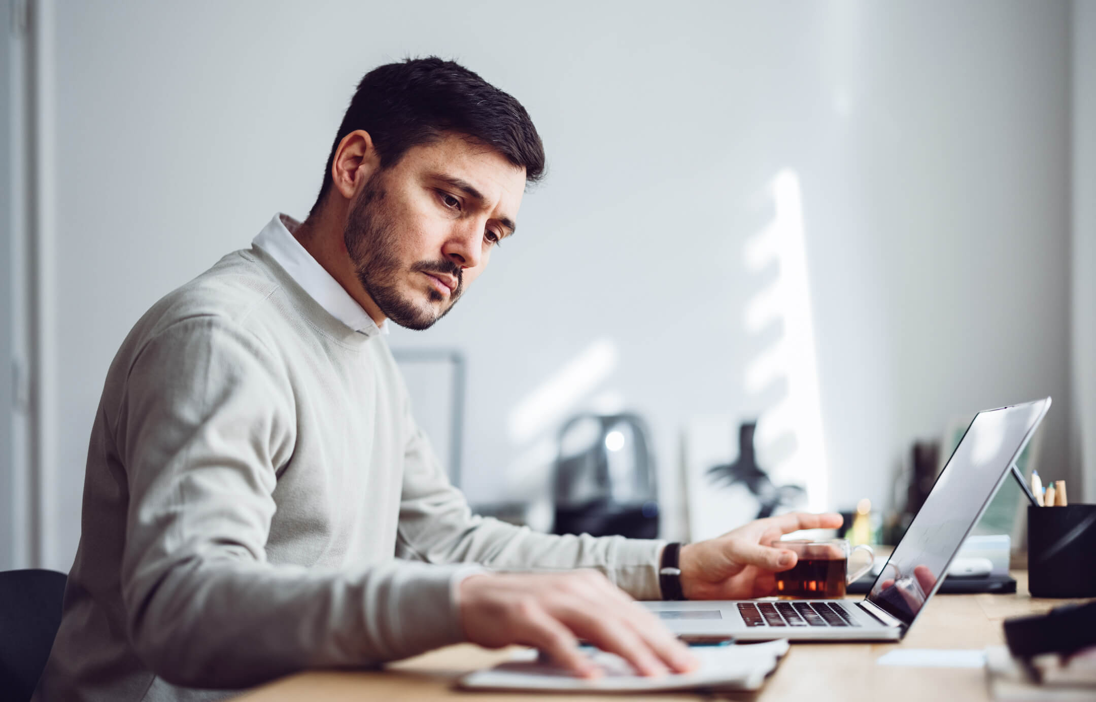 Bilgisayar başında çalışan ciddi görünümlü genç