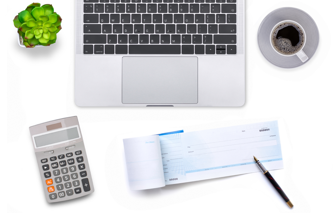 a checkbook and pen lying in front of the computer