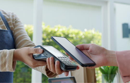 POS cihazına telefonla temassız ödeme yapan müşteri