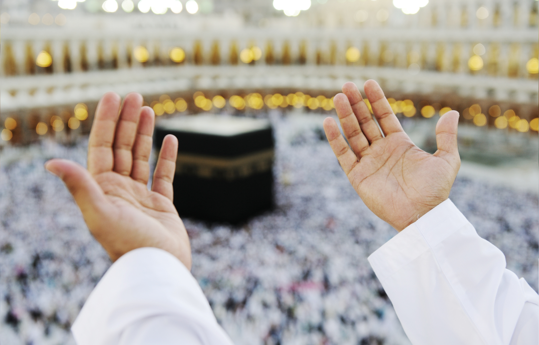 A pilgrim praying with his hands raised at the Kaaba