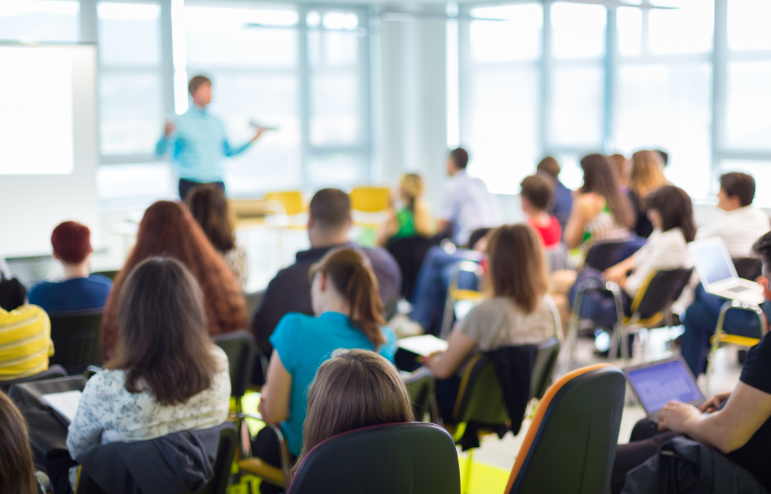 People attending a seminar with a speaker presenting at front