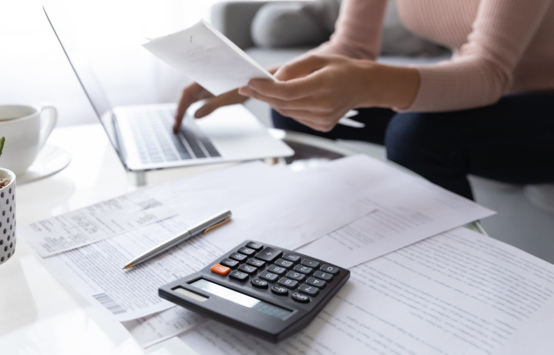 someone who works at a desk with a calculator and bills