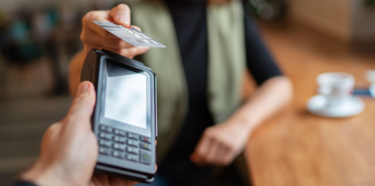Person paying with card at a handheld payment terminal