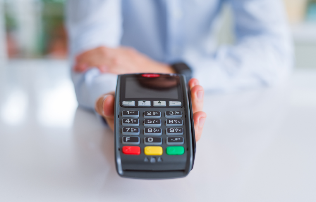 the person holding the pos device in his hand