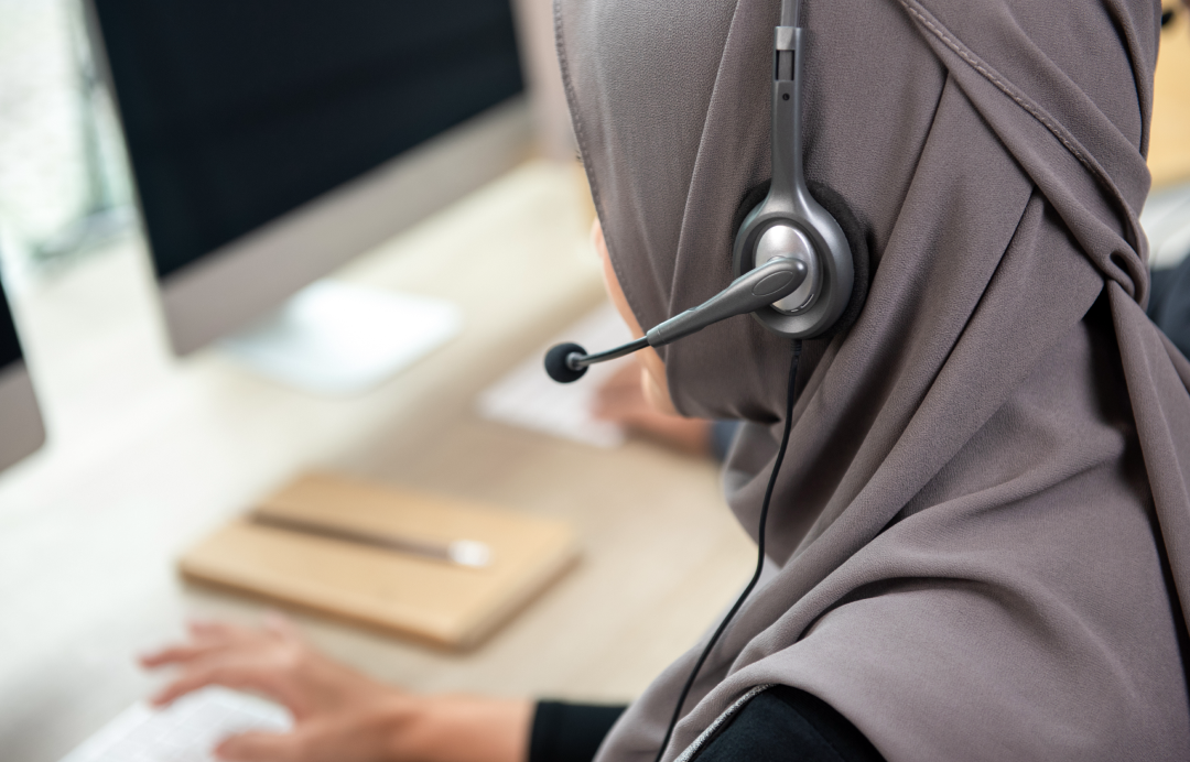 someone who works at a computer with headphones on Customer Satisfaction Center