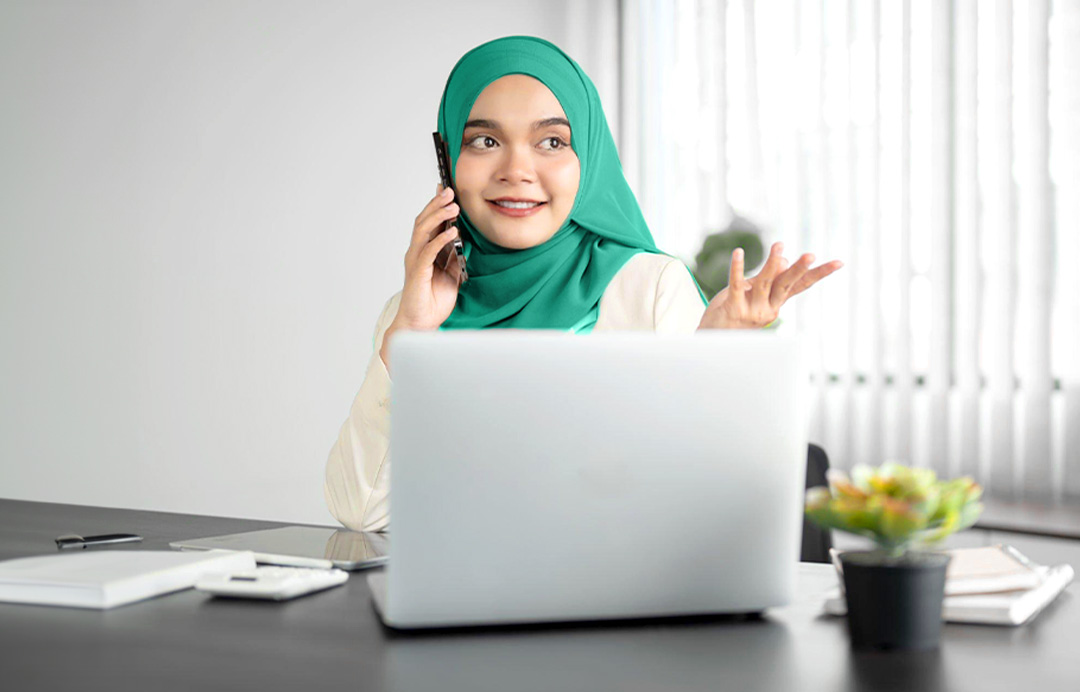 the woman talking on the phone at the computer