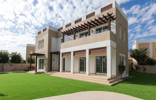 Geniş çim bahçeli iki katlı beyaz bir villa