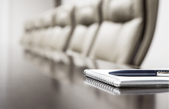 Pen resting on a notebook on a meeting table