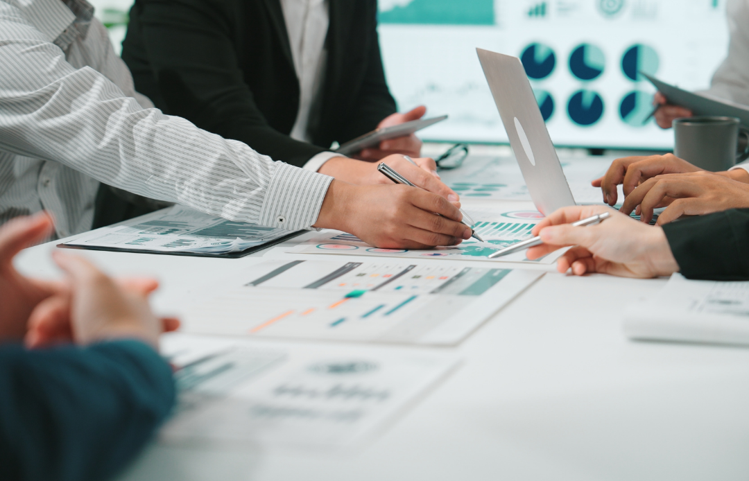 Team members discussing charts around a meeting table