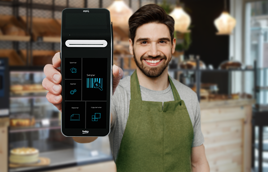 Kafede çalışan kişi ödeme uygulaması açık telefonu gösteriyor