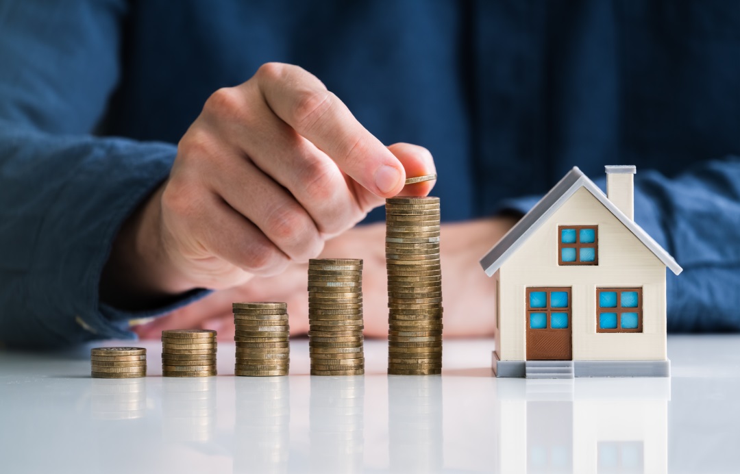 Hand stacking model house and coins