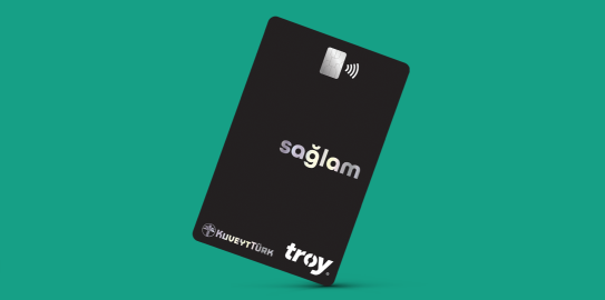 Black Kuveyt Turk Sağlam contactless credit card on green background