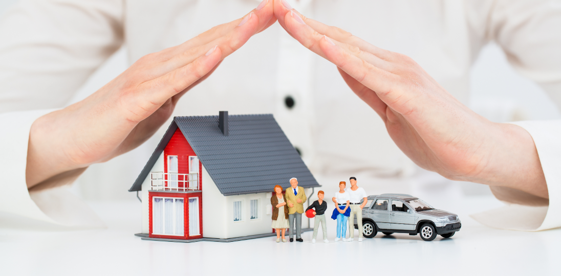 Hands forming a roof over a house family and car symbolizing insurance