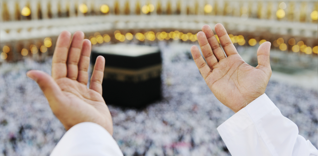 A pilgrim praying with his hands raised at the Kaaba