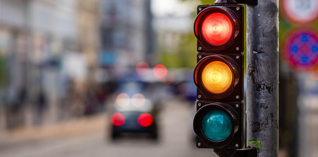 traffic light showing red yellow and green on a city street