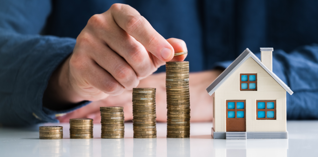 Hand stacking model house and coins