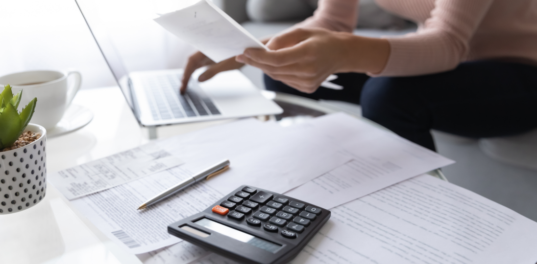 someone who works at a desk with a calculator and bills