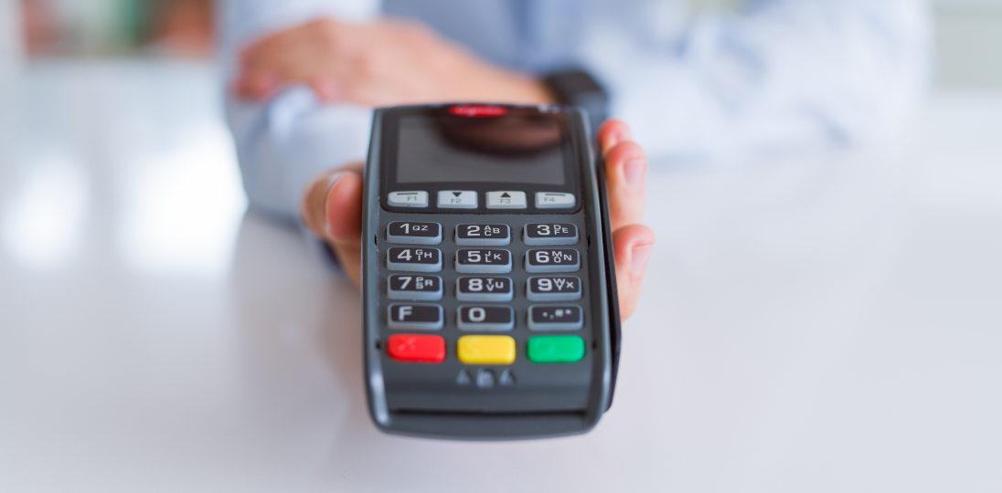 the person holding the pos device in his hand