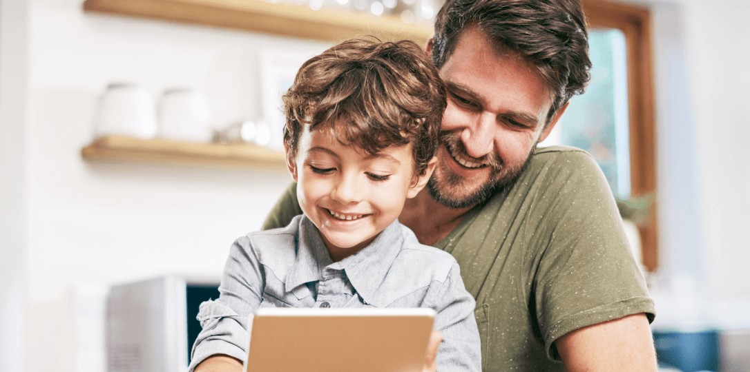 father looking at the tablet screen with his son