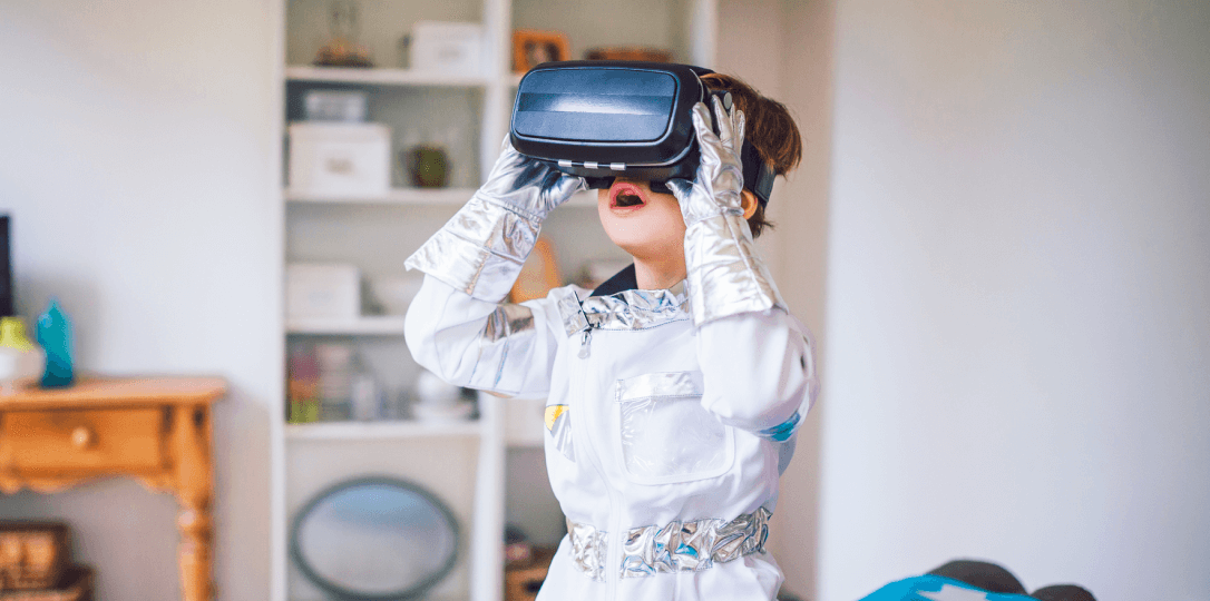 A child wearing a virtual reality headset and an astronaut costume
