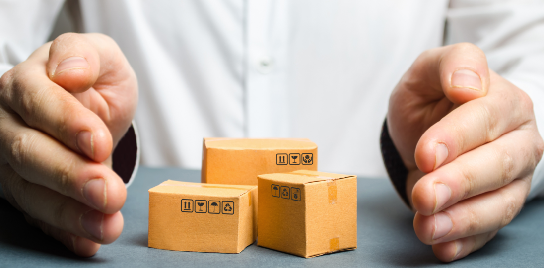 hands protecting miniature shipping boxes