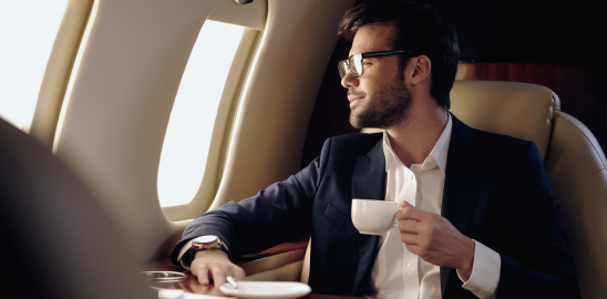 a person drinking coffee while traveling on a private jet