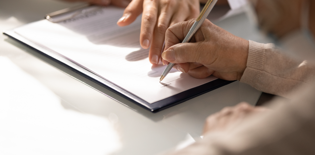 Person signing a document on a digital tablet