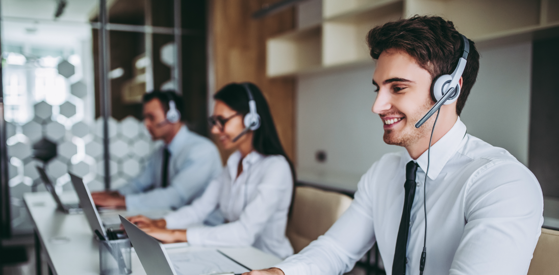 Call center agents conducting customer interviews while using headphones at their computers