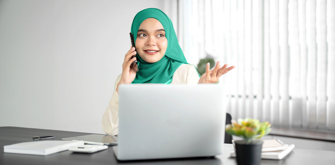 the woman talking on the phone at the computer