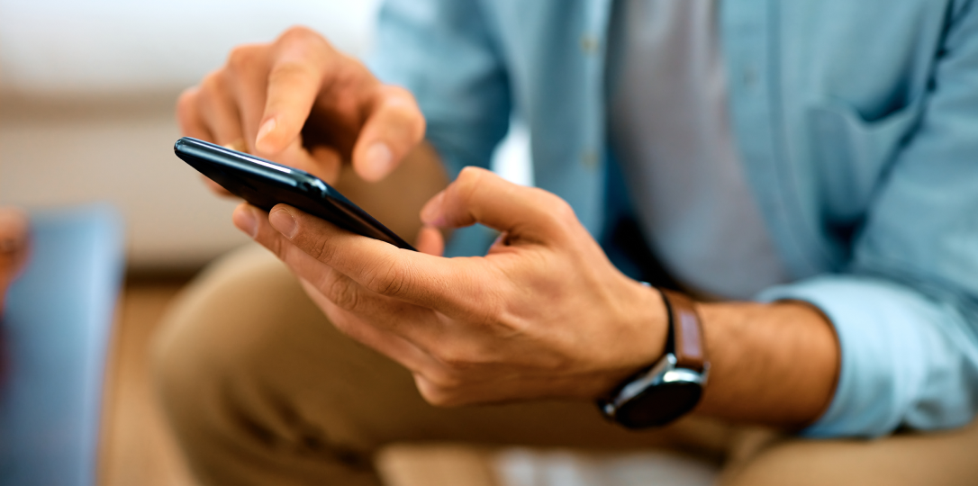 elindeki akıllı telefonu kullanan kişi