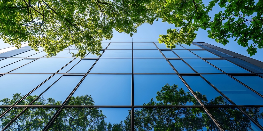 Moden glass building with reflections of surrounding tress