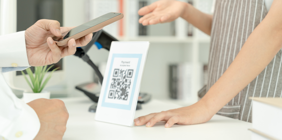 QR kodu gösteren satış danışmanı ve telefonuna bakan müşteri