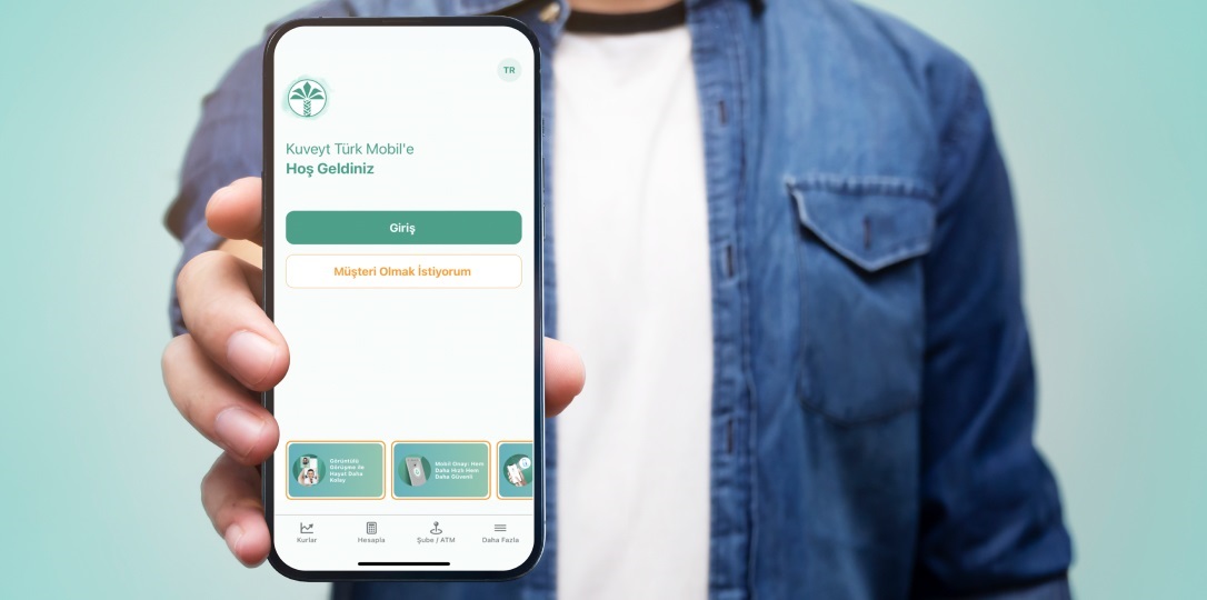 The person holding the phone is showing the Kuveyt Türk Mobile application