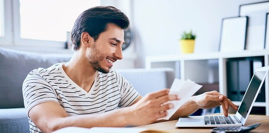 young person doing financial transactions at computer